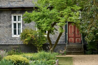 Gevel van een huis met tuin in de nazomer