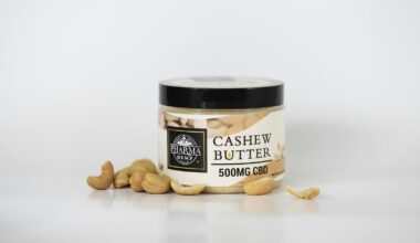 Romige witte cashewroom in een glazen pot naast een schaaltje cashewnoten