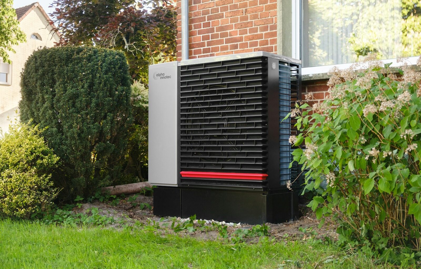 Buitenunit van een warmtepomp in de tuin