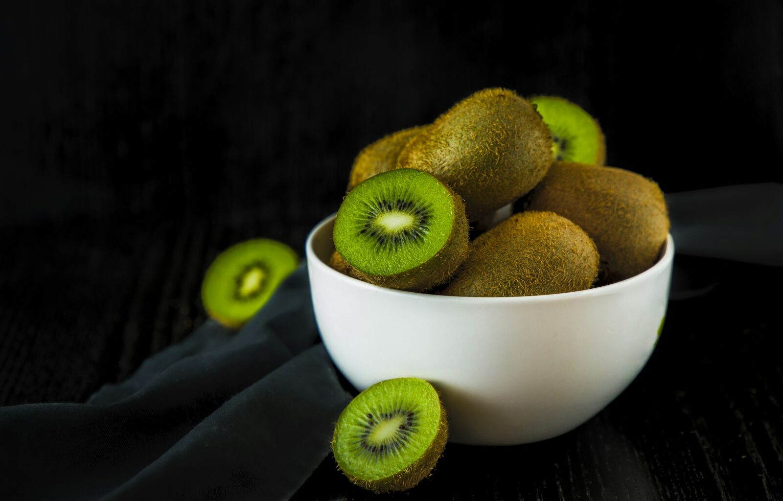 Schaaltje kiwibessen, een paar doormidden gesneden met groen vruchtvlees
