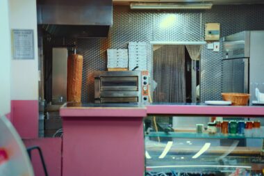 Afhaalloket van een snackbar met een rij wachtende mensen op straat