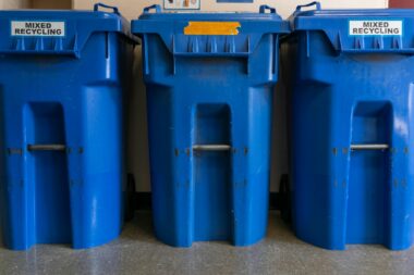 a couple of blue trash cans sitting next to each other