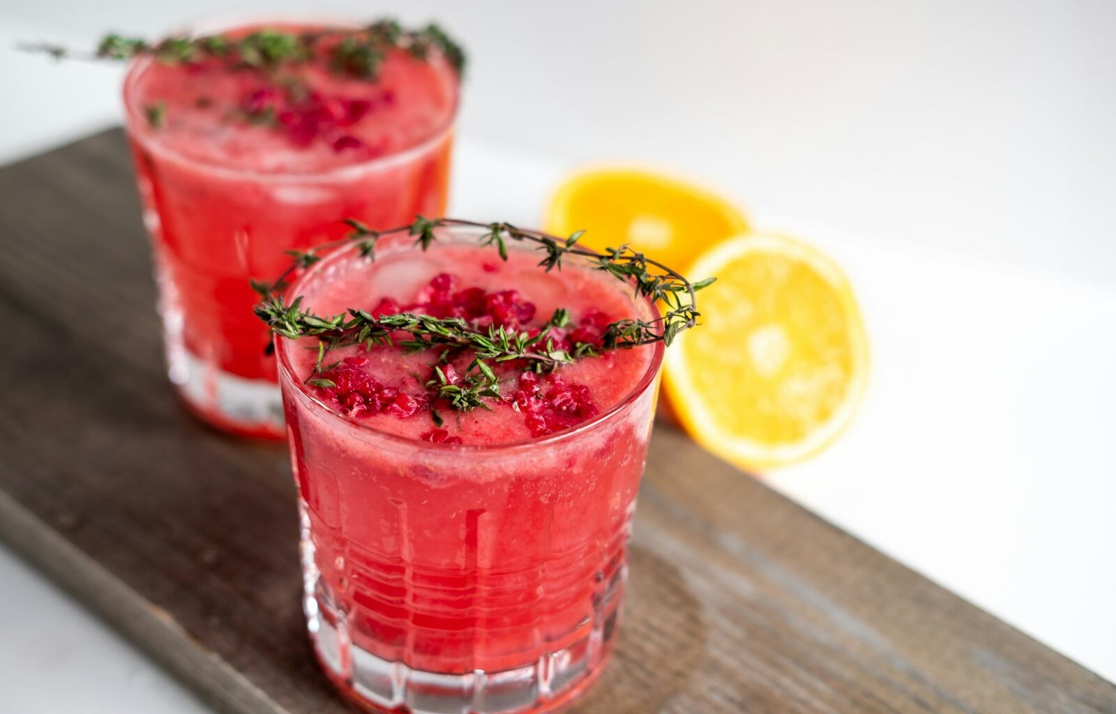 Alcoholvrije cocktails met granaatappel en rozemarijn op een feestelijk gedekte tafel