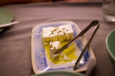 Blokjes witte kaas in olijfolie met oregano in een glazen pot