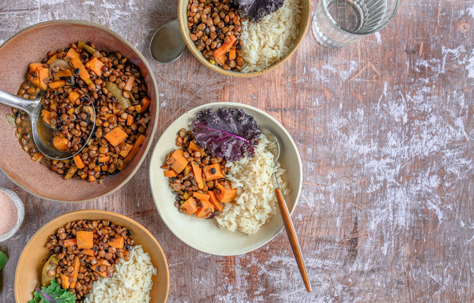 Kommen met tofu, linzen, kikkererwten en quinoa op een houten tafel