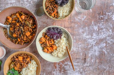 Kommen met tofu, linzen, kikkererwten en quinoa op een houten tafel