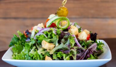 Salade in een kom met de dressing apart in een klein schaaltje ernaast