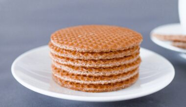Stapel stroopwafels op een bordje naast een kop koffie