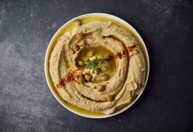 Kom hummus met olijfolie en kikkererwten op tafel