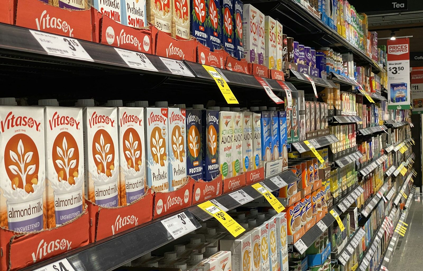 Schap met flessen plantaardige olie en zakken gedroogde peulvruchten in een supermarkt